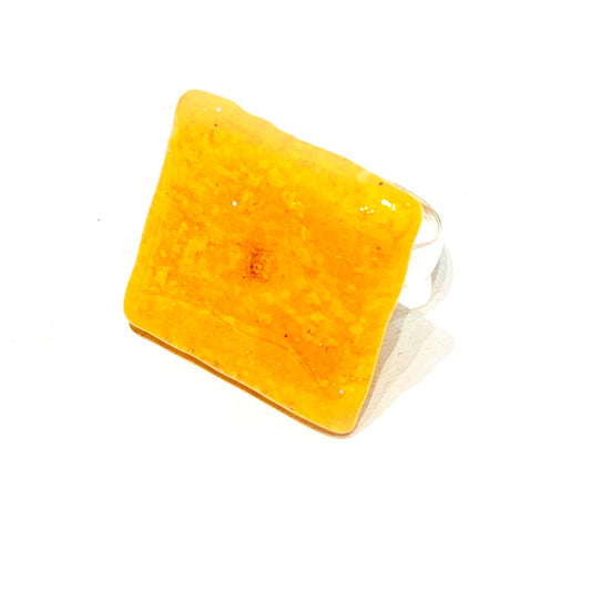 Close up of cheez-it ring coated in resin and attached to silver ring band 