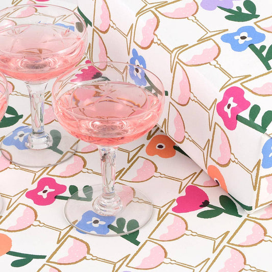 Two glasses of pink drink on a floral-patterned gift wrap