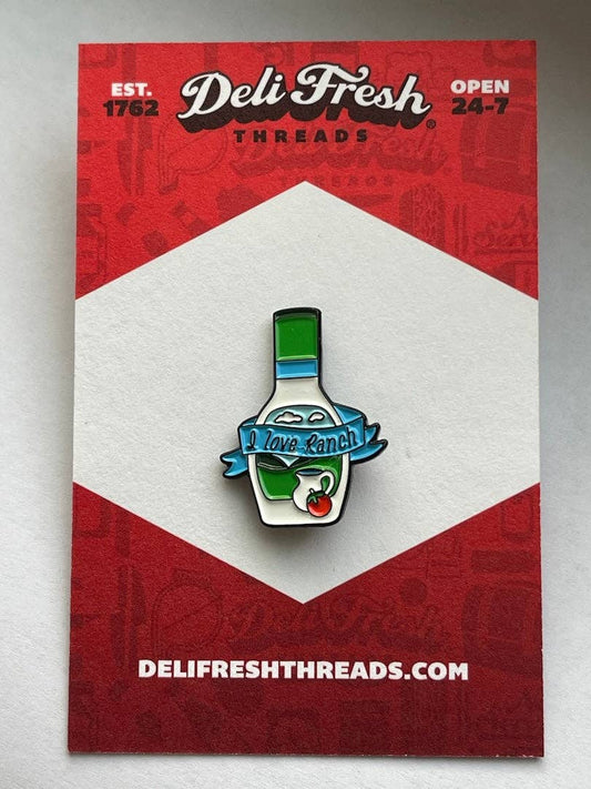 Ranch bottle lapel pin that has a ribbon across the bottle that says "I love Ranch". on a card backing that reads Deli Fresh.