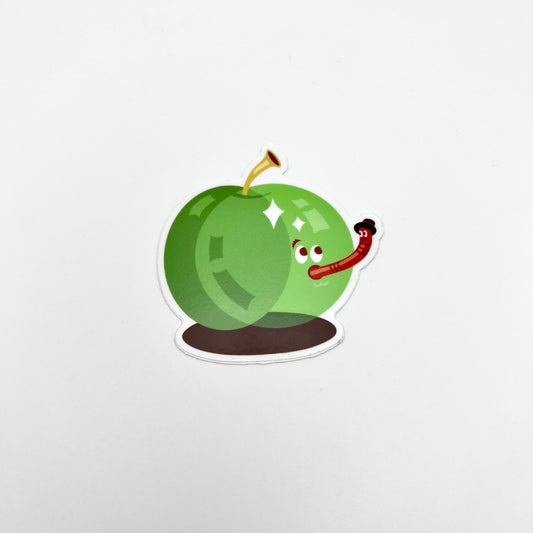 Apple sticker. Green apple with a worm coming out of his mouth. THe worm is wearing a hat.