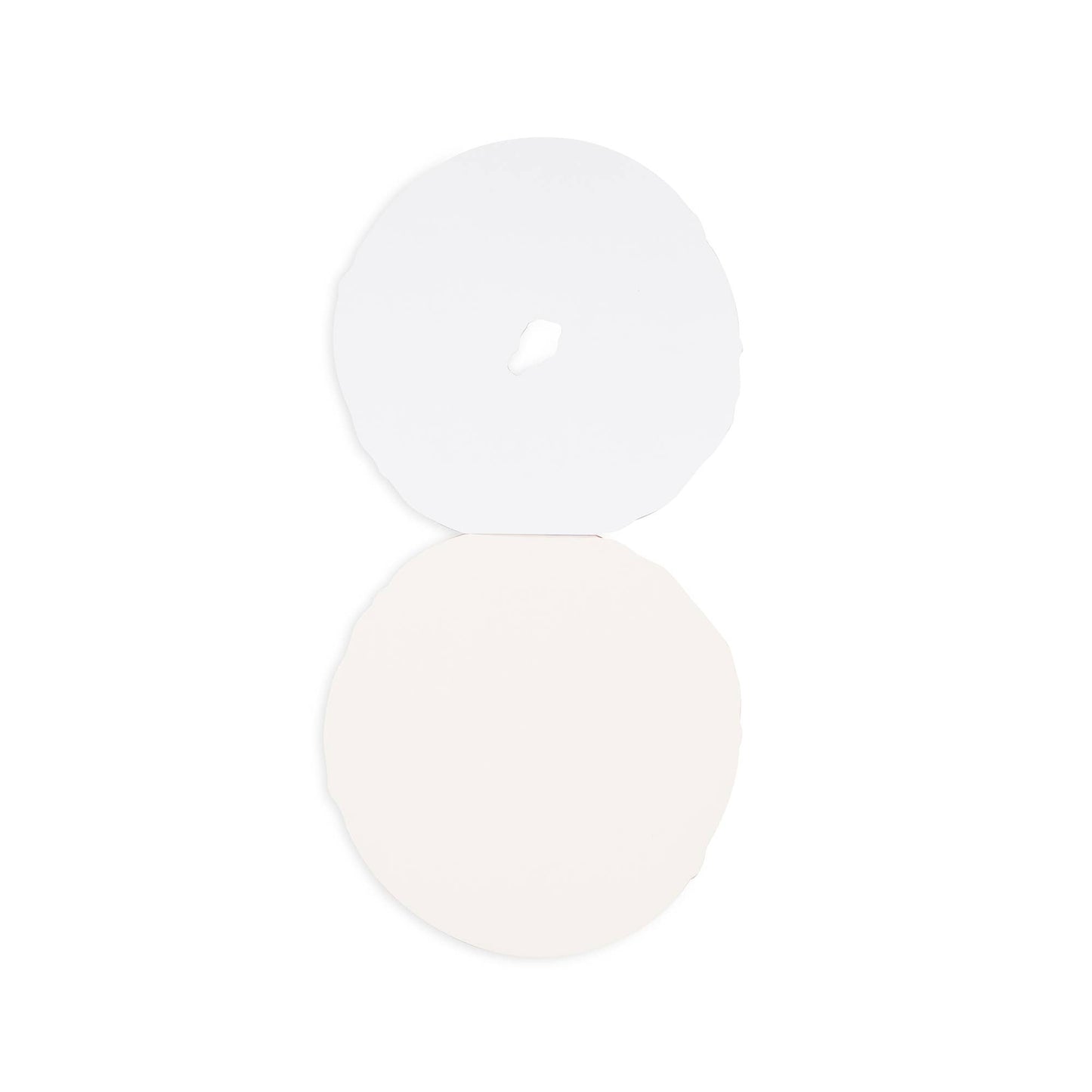 Two white circular objects on a light beige background. Interior shot of the bagel notepad showing blank pages.