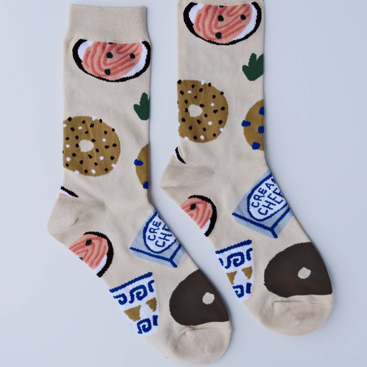 Pair of women's socks -- light tan with bagels, lox and cream cheese on it
