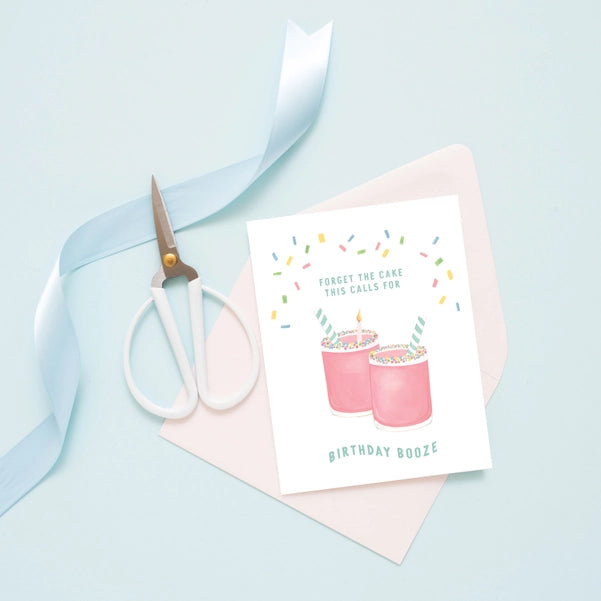 Birthday Booze greeting card shown on blue background with blue ribbon and blue scissors.