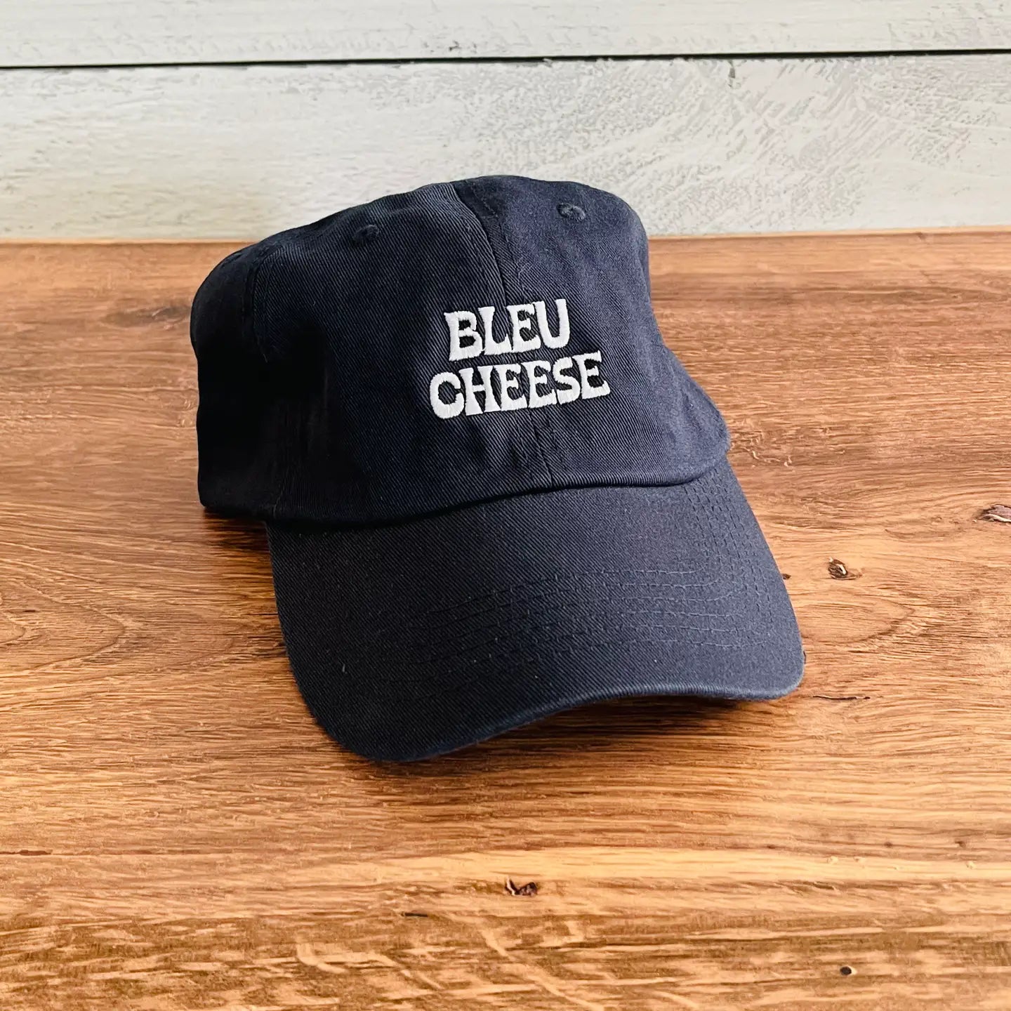 Navy cap with light blue text that reads "Bleu Cheese"