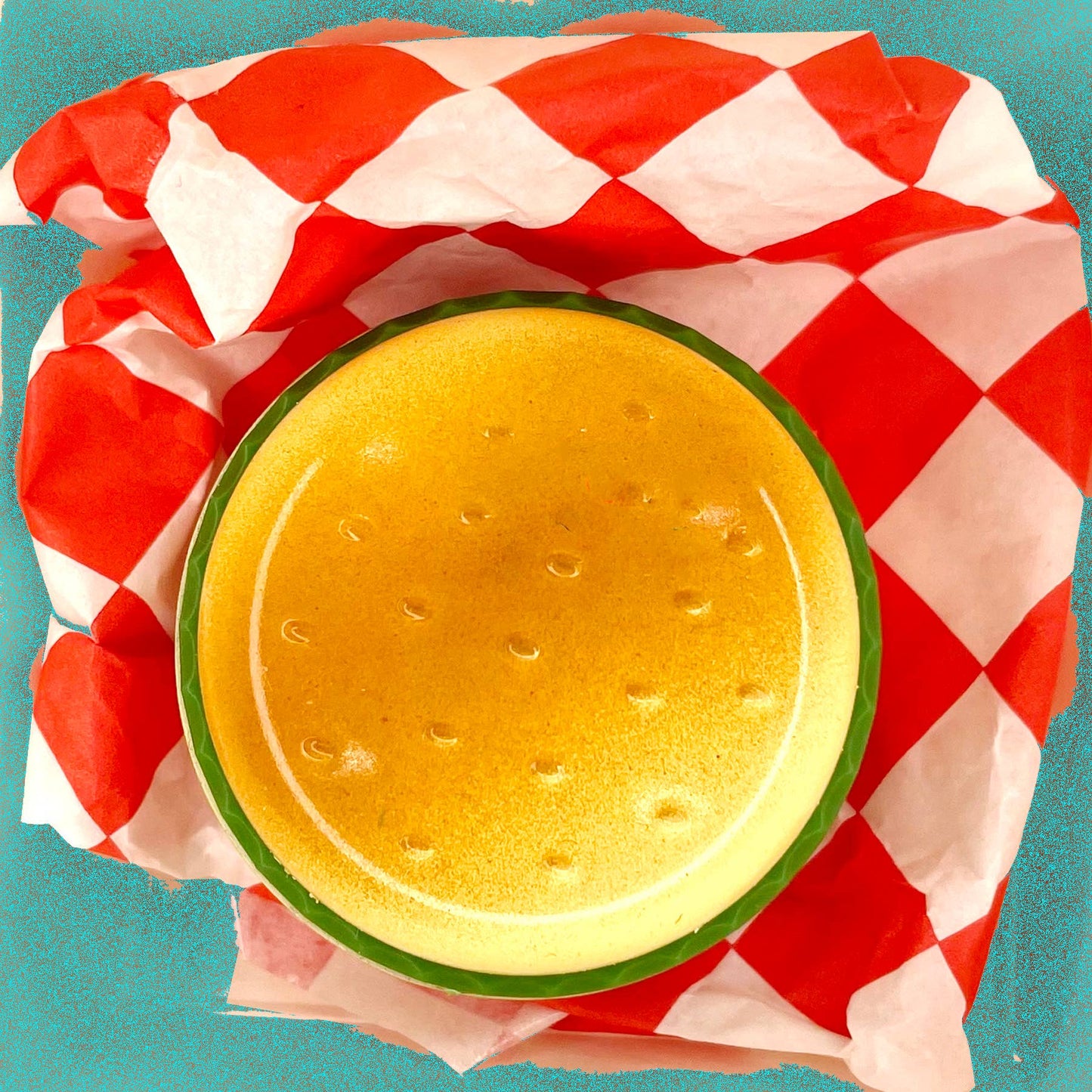 Butane lighter shaped like a hamburger. Shown on top of red and white checkered deli paper.