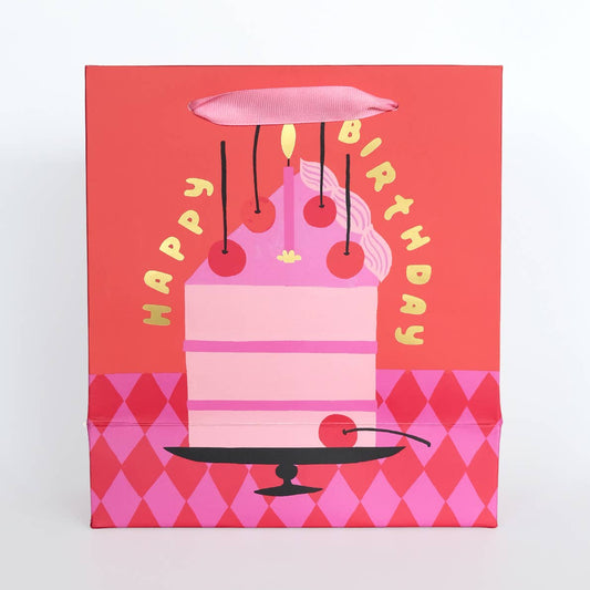 Gift bag with a pink birthday cake design on a red background