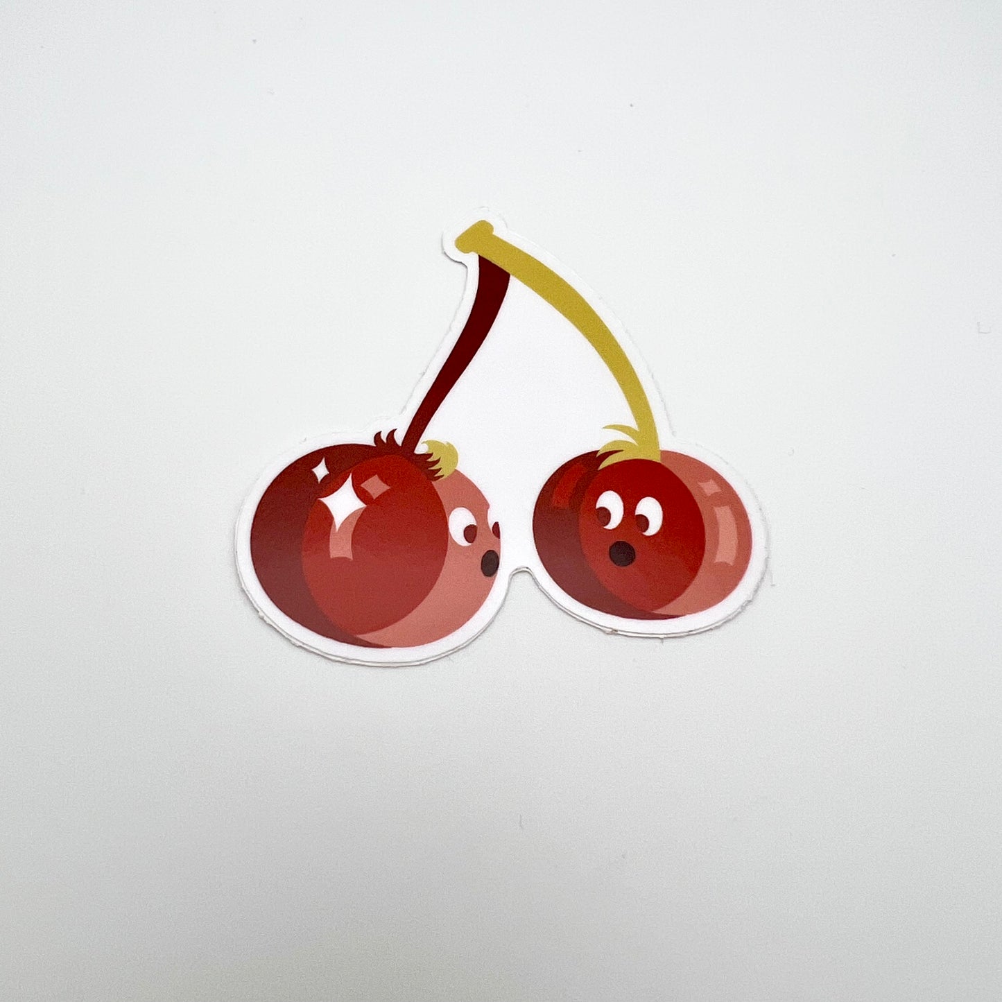 Cherry sticker. Each berry has a face and they are looking at each other.