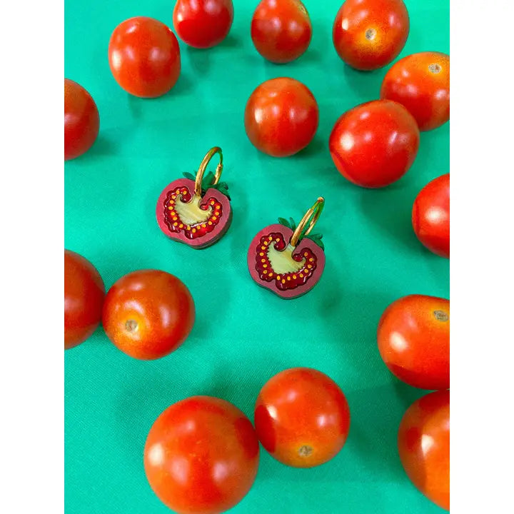 Cherry tomatoes laying on a turquoise background with real cherry tomatoes surrounding them