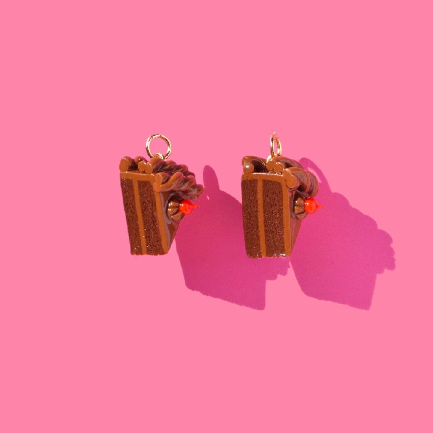 Chocolate Cake Slice earrings on a pink background