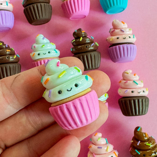 Small cupcake-shaped magnet with faces on a pink background