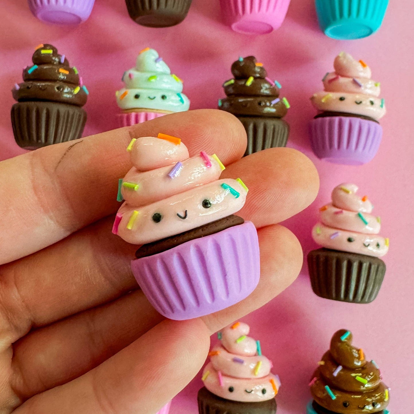 Small cupcake-shaped magnets with faces on a pink background