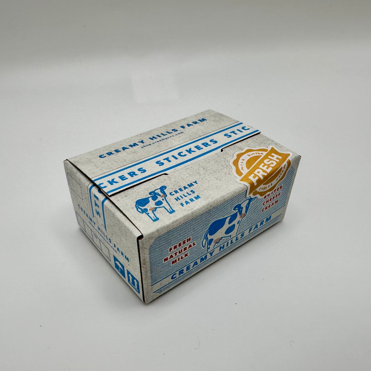 Dairy farm sticker box with a cow and text that includes: Creamy Hill Farms, Fresh, stickers, fresh natural milk.