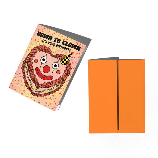 Birthday card with clown design and orange envelope on a white background