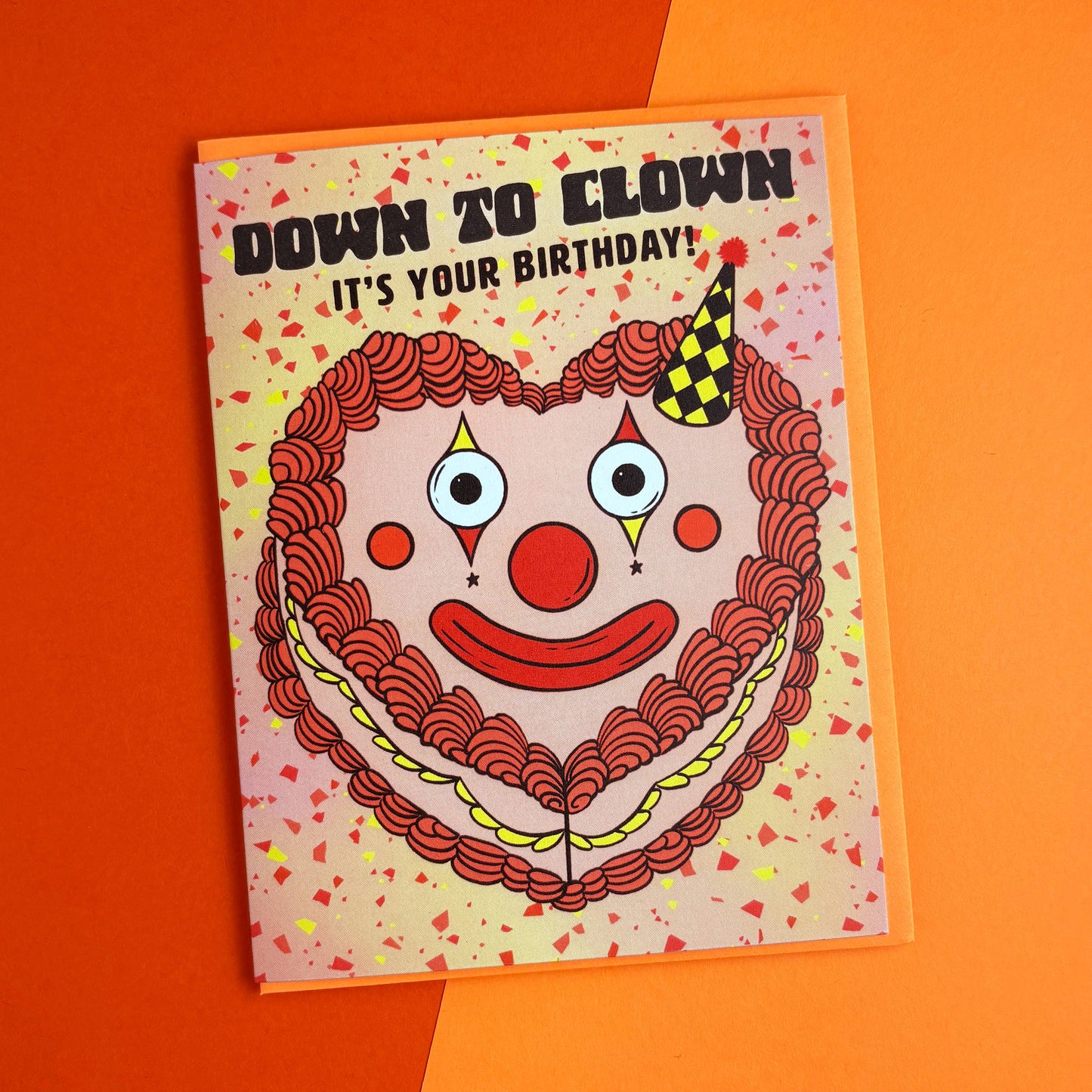 Birthday card with clown face design on an orange background
