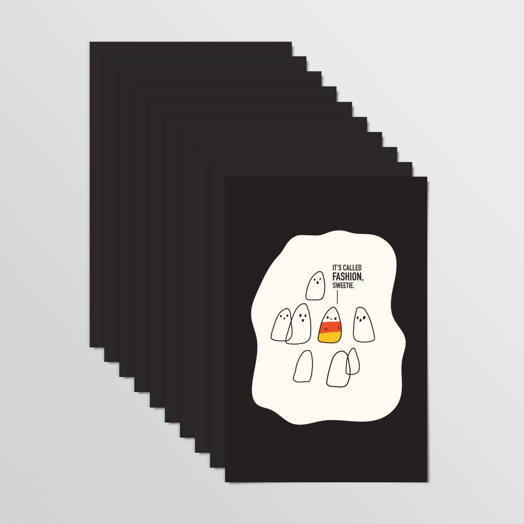 A stack of black post cards fanned out on a light gray background. The front card features a white irregular shape with a minimalist cartoon of ghost-like figures and the text 'IT'S CALLED FASHION, SWEETIE.'