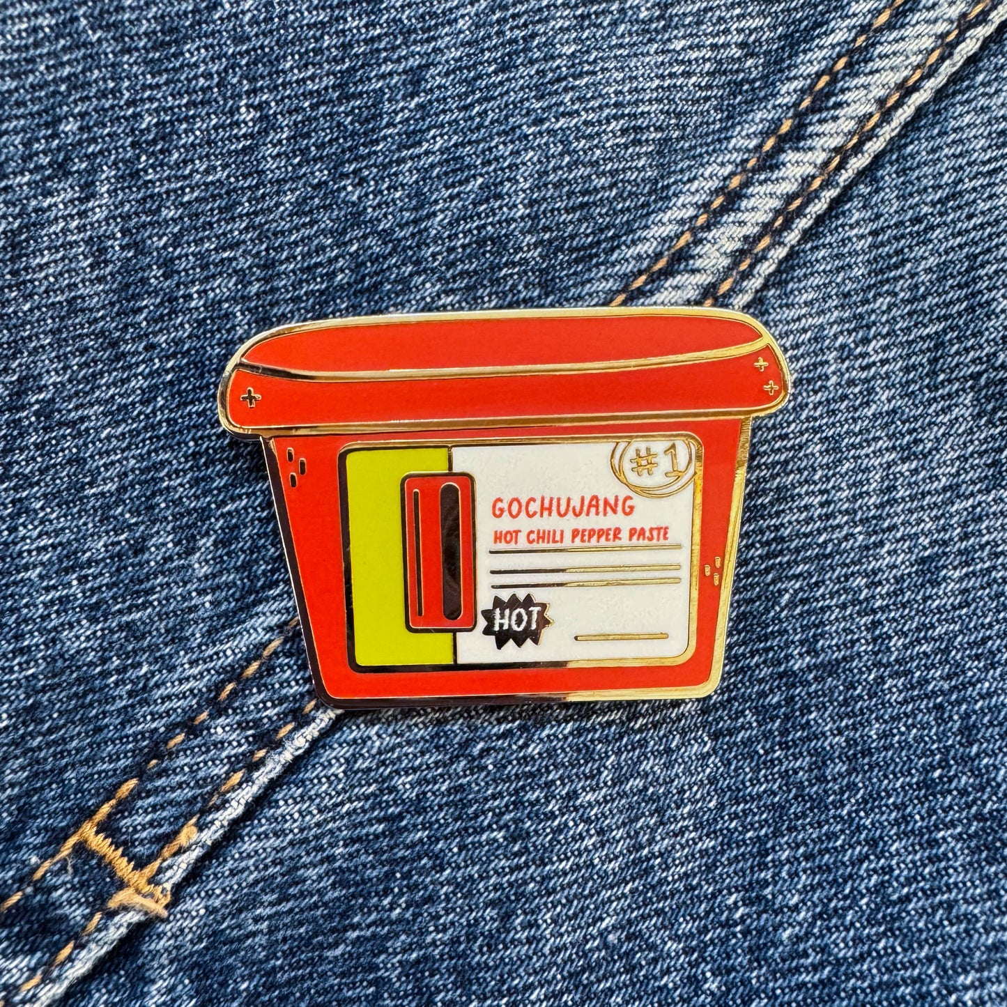 Enamel pin of korean Gochujang container on denim fabric