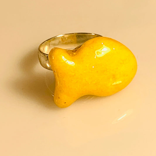Goldfish cracker snack coated in resin with a metal band attached to make it into a ring 