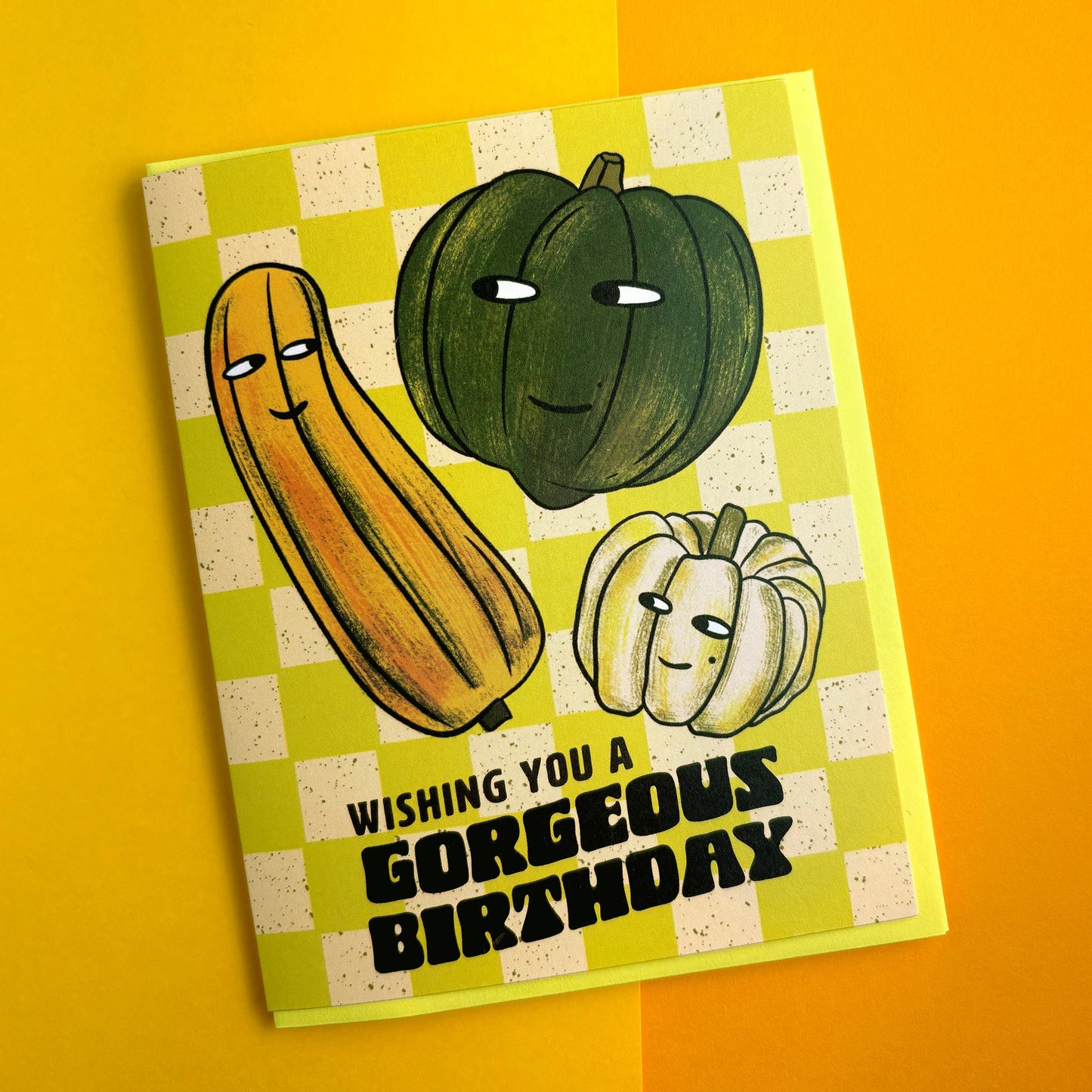 Birthday card with cartoon squash characters on a checkered background