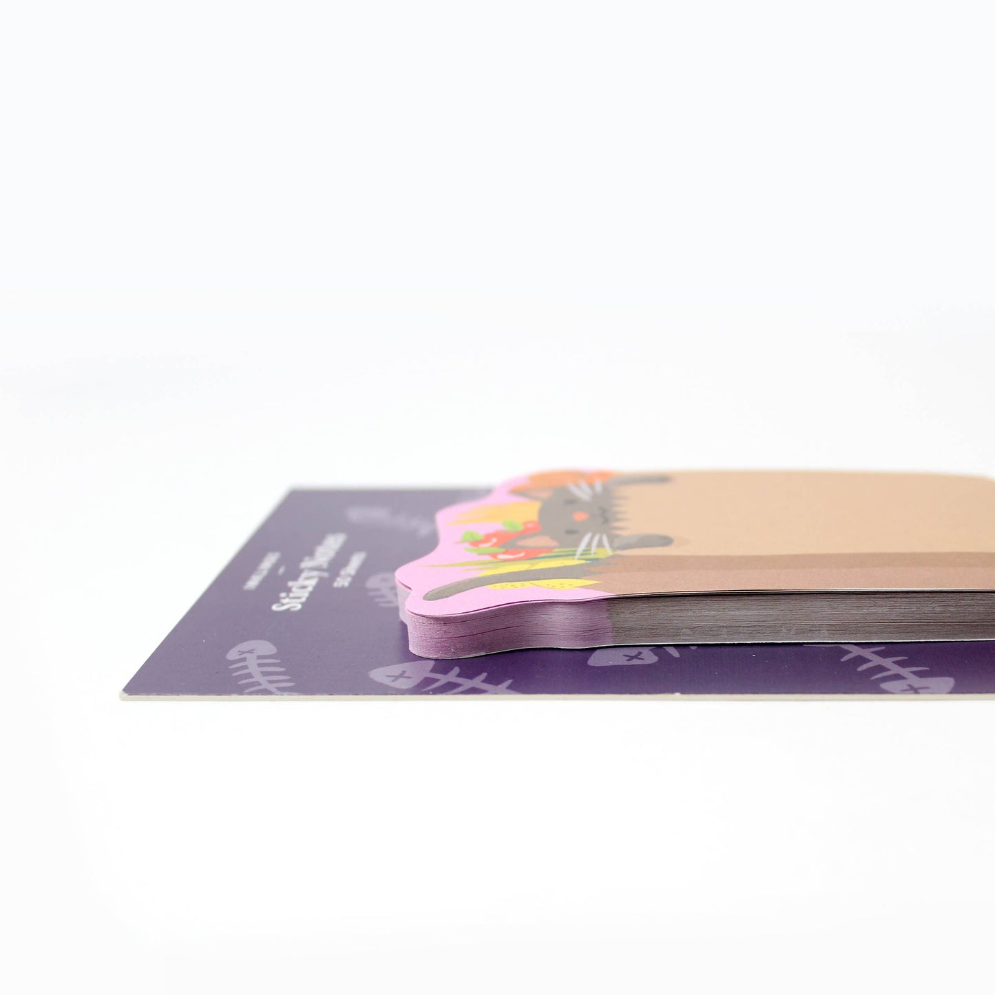 Stack of colorful sticky notes on a purple pad with a white background