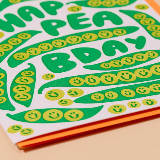 close up of pea themed birthday card with orange envelope