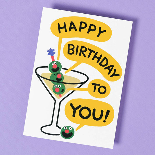 Birthday card with a martini glass and olives on a purple background