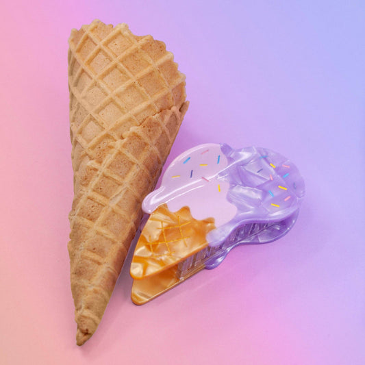 Hair claw made to look like two scoops of ice cream (one pink, one purple) melting on a waffle cone. Pictured here next to an actual waffle cone