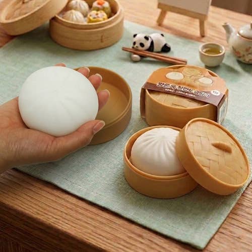 Bamboo steamer with bao bun squishies on a wooden table