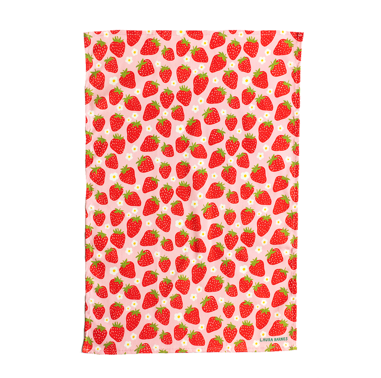 Detail photo of tea towel - print features strawberries and small white flowers on pale pink background.
