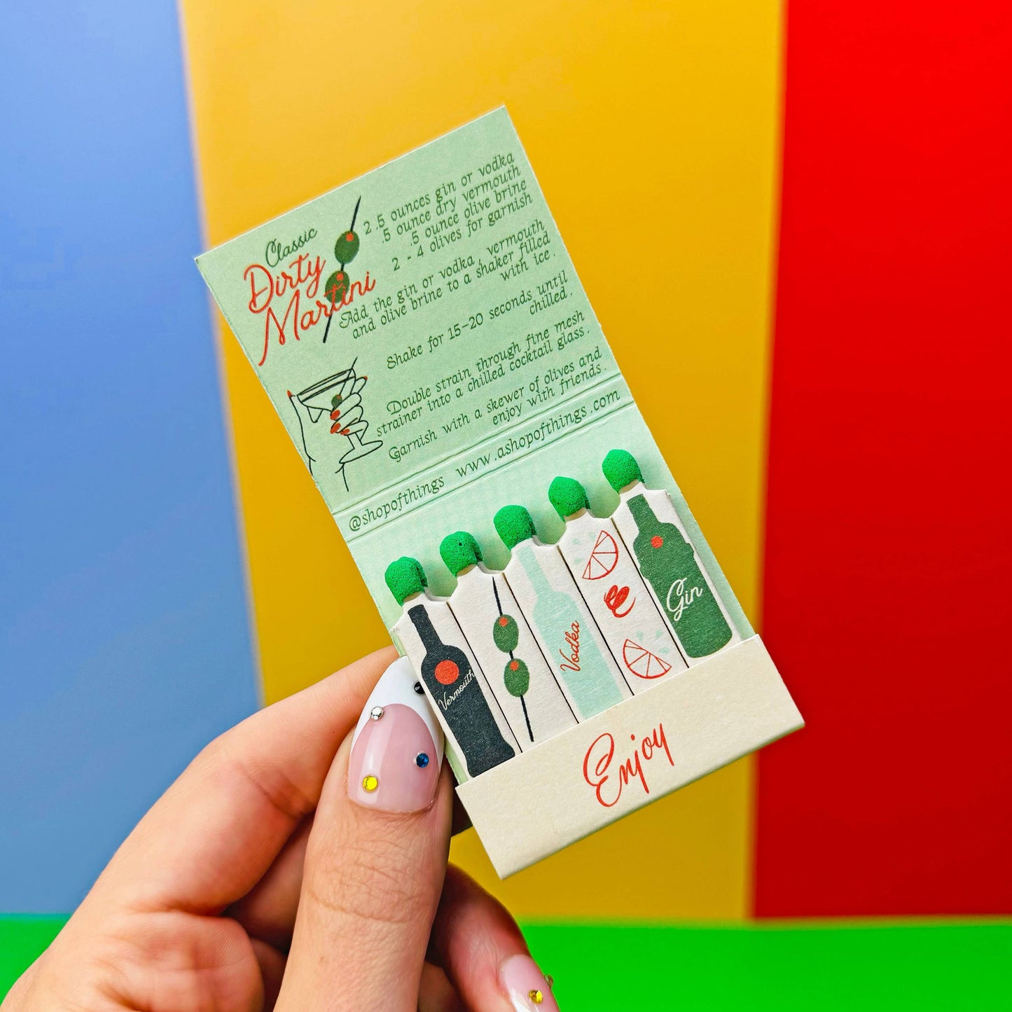Matchbook in Dirty Martini theme. Each match is an ingredient in making this classic cocktail. Recipe is also written inside the matchbook. Book also says Enjoy.