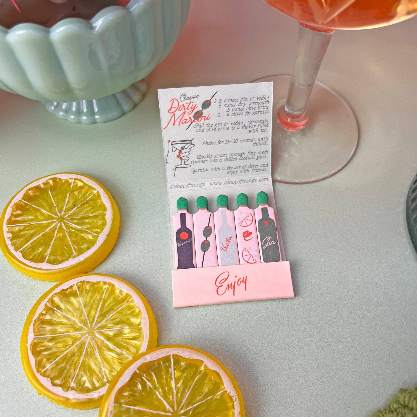 Matchbook in Dirty Martini theme. Each match is an ingredient in making this classic cocktail. Recipe is also written inside the matchbook. Book also says Enjoy.