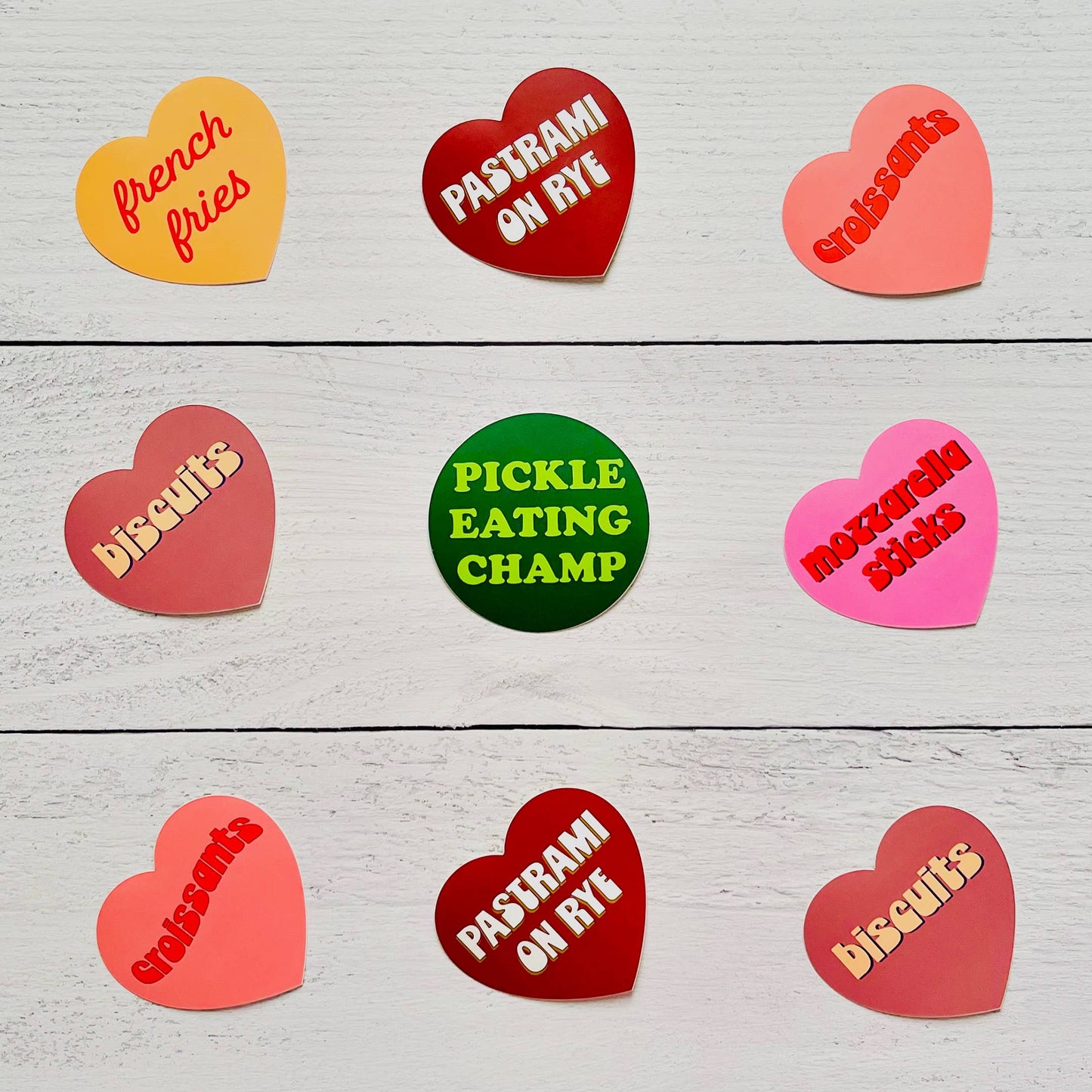 Heart-shaped stickers with various text on a wooden surface