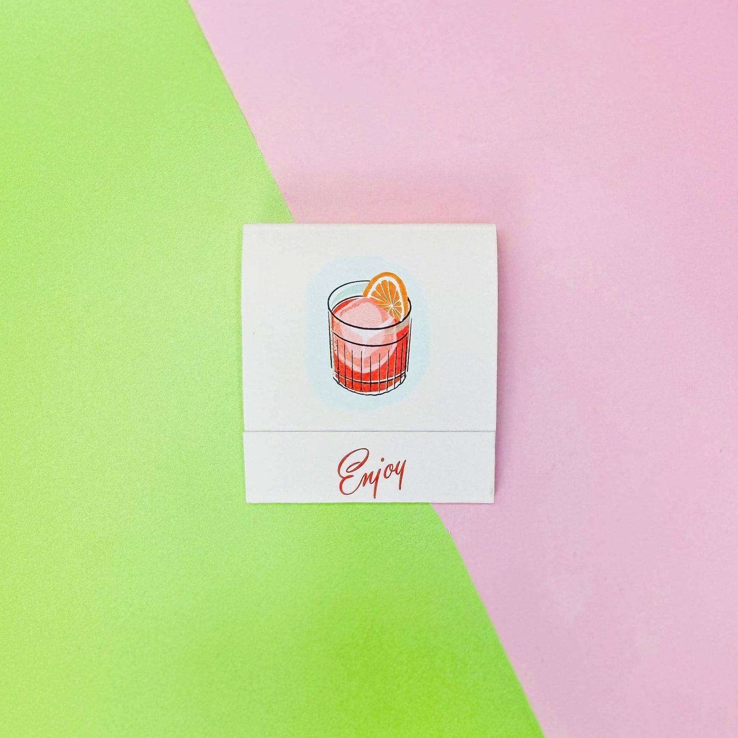Exterior of front of Negroni matchbook -- designed with a negroni cocktail in center and on bottom flap it reads "Enjoy"