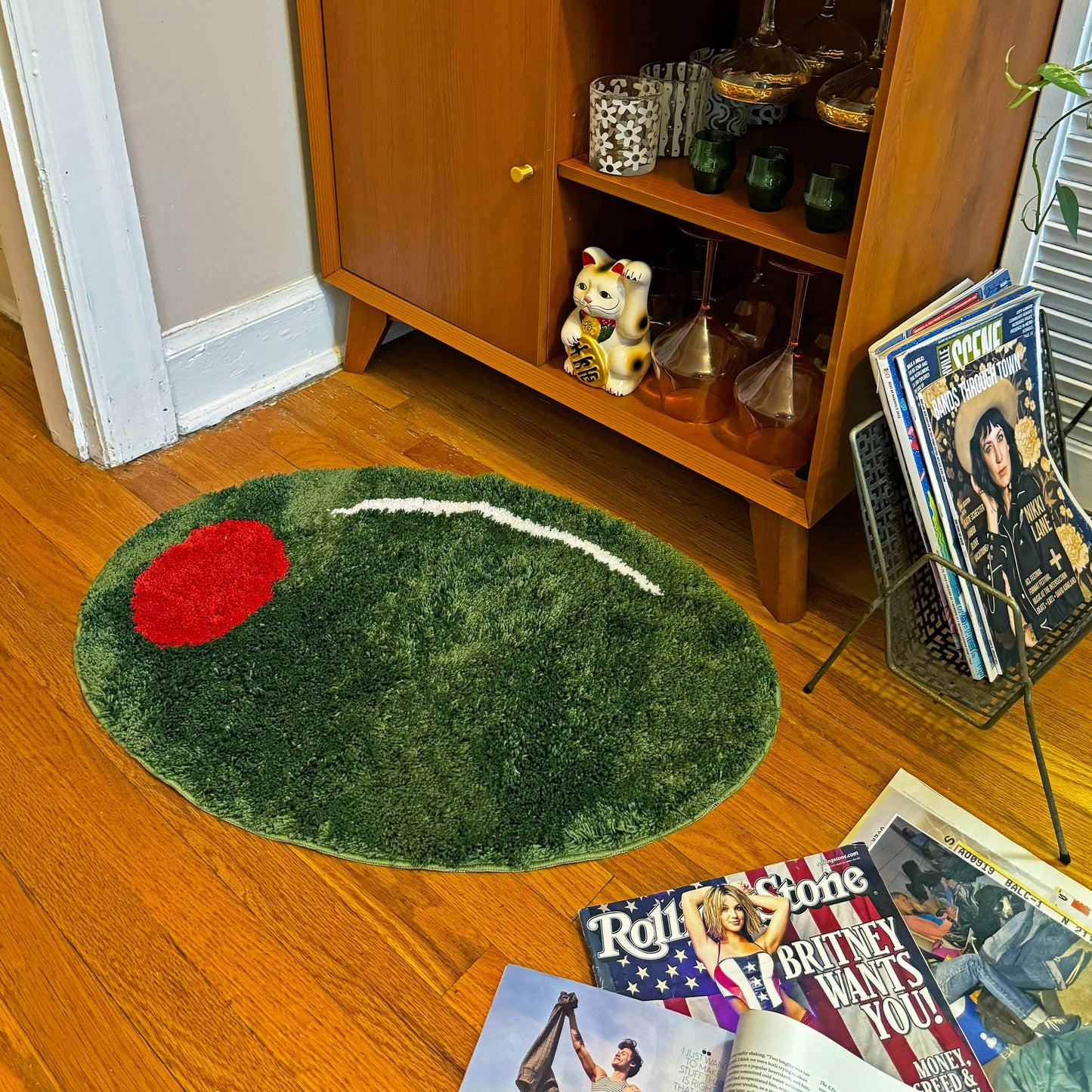 Stuffed green olive rug in front of bar cart