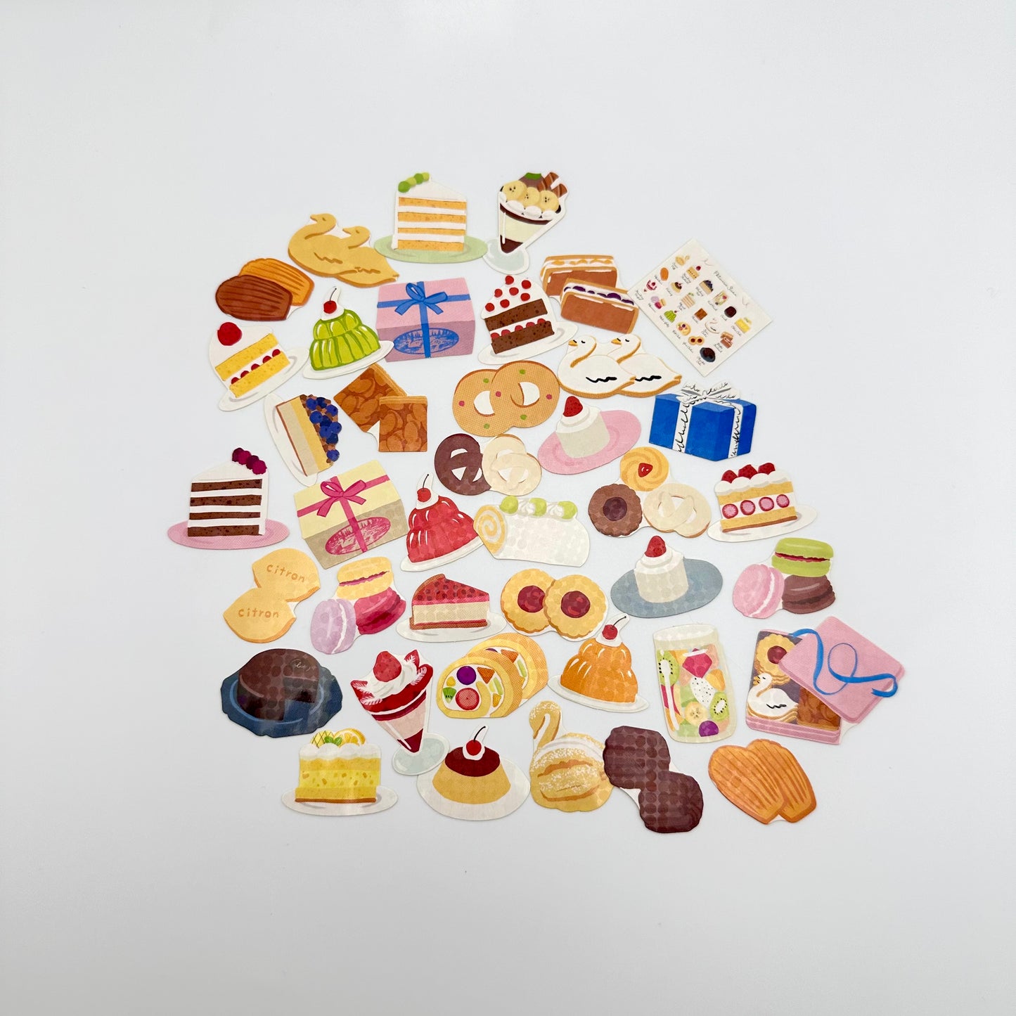 Many little hologram stickers that looks like assorted pastries, cookies and cakes.