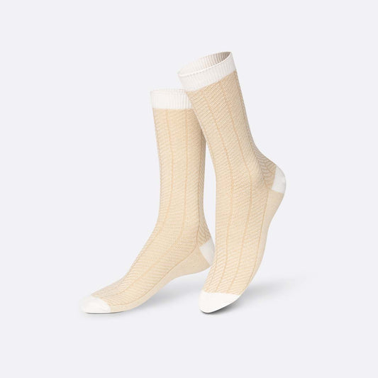 Pair of beige socks with white accents on a light gray background