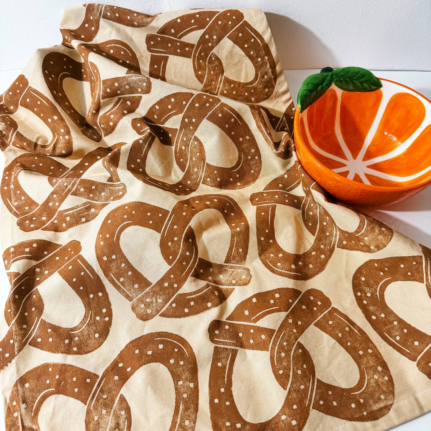 kitchen towel designed with a repeated patter of soft, salted pretzels