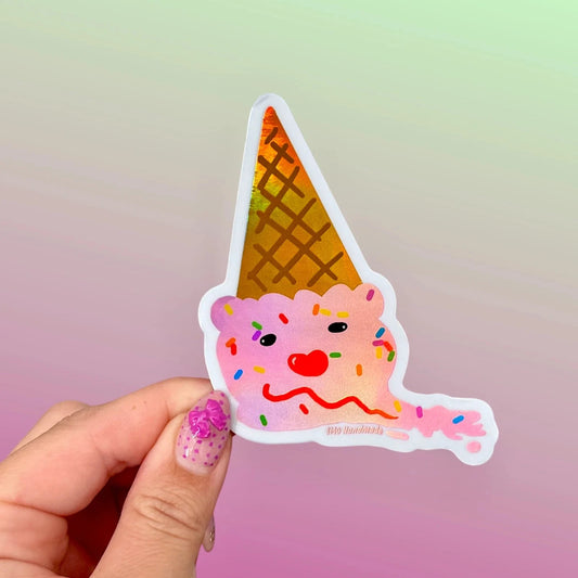 a melted and upside down pink ice cream cone with sprinkles being held