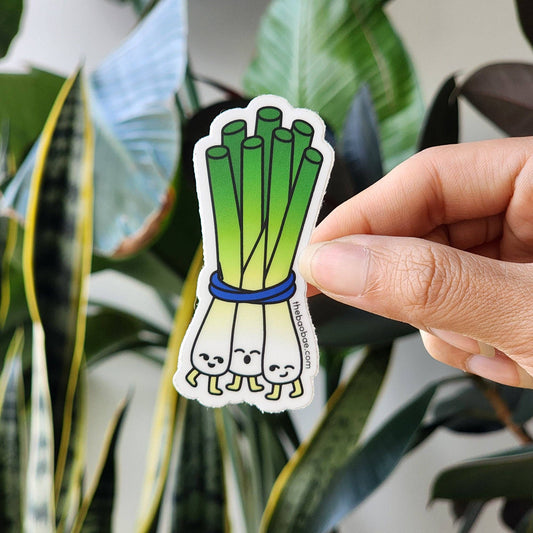 scallion bunch sticker held by a hand in front of plant background