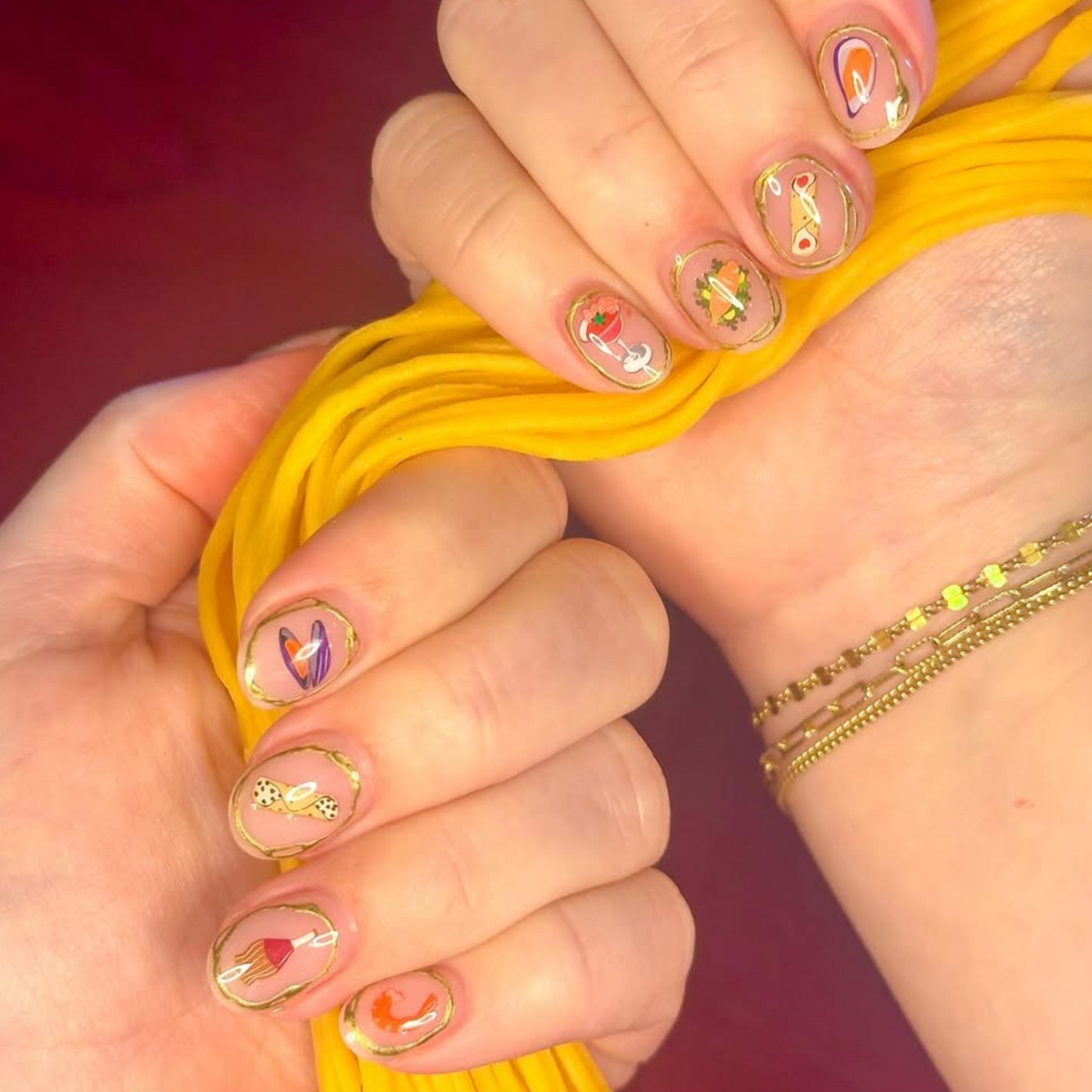 Feast of Seven Fishes themed nail decals - includes scungilli, clams, calamari, shrimp cocktail, tomato can, chianti bottle, wine glass, christmas bows and holly, and more. Shown on short nails with gold and clear polish.