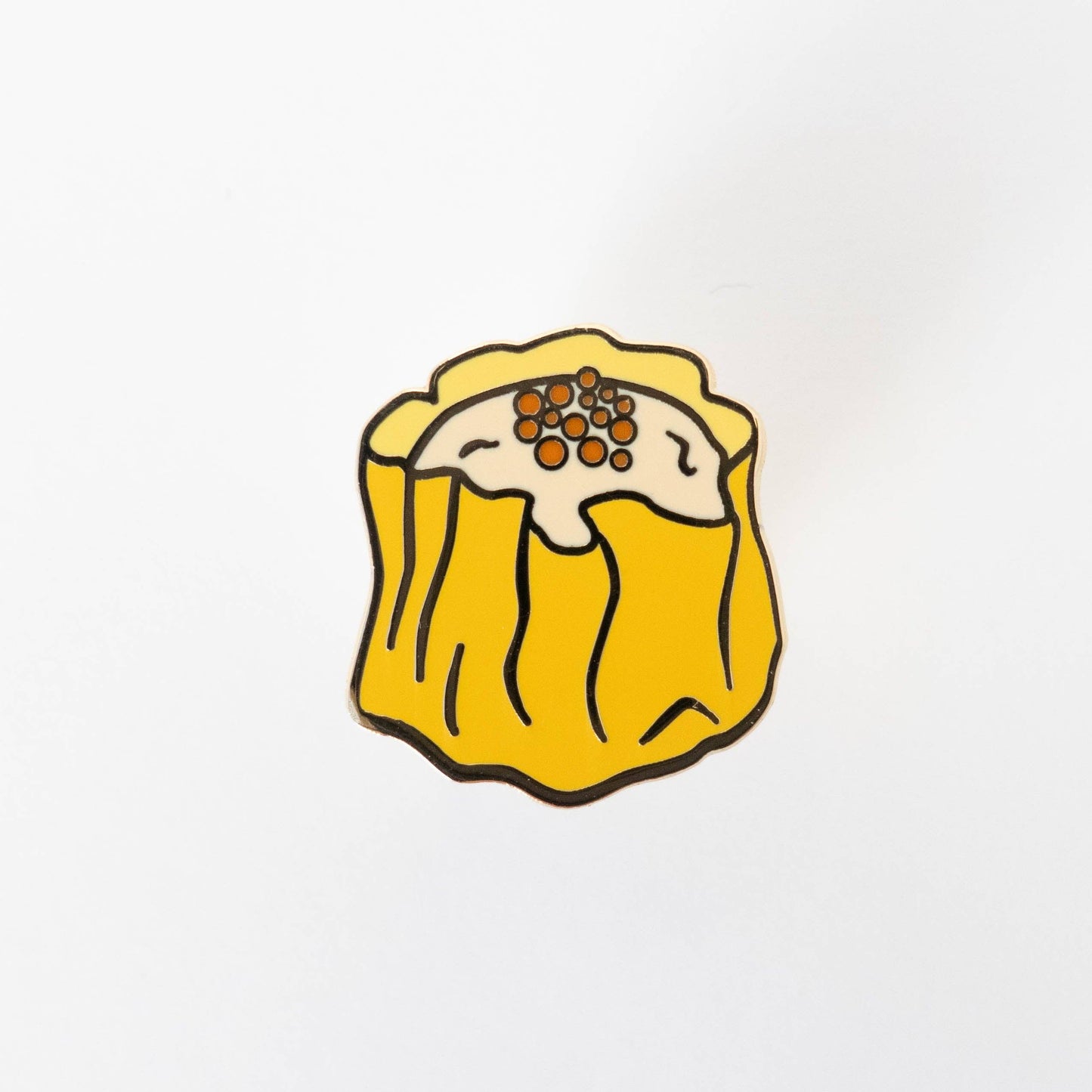 Enamel lapel pin shaped like Siu Mai (Chinese dumpling) shown without cardboard backing board.