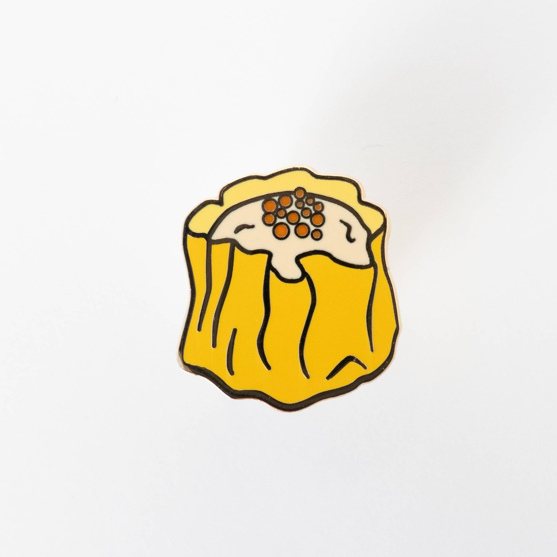 Enamel lapel pin shaped like Siu Mai (Chinese dumpling) shown without cardboard backing board.
