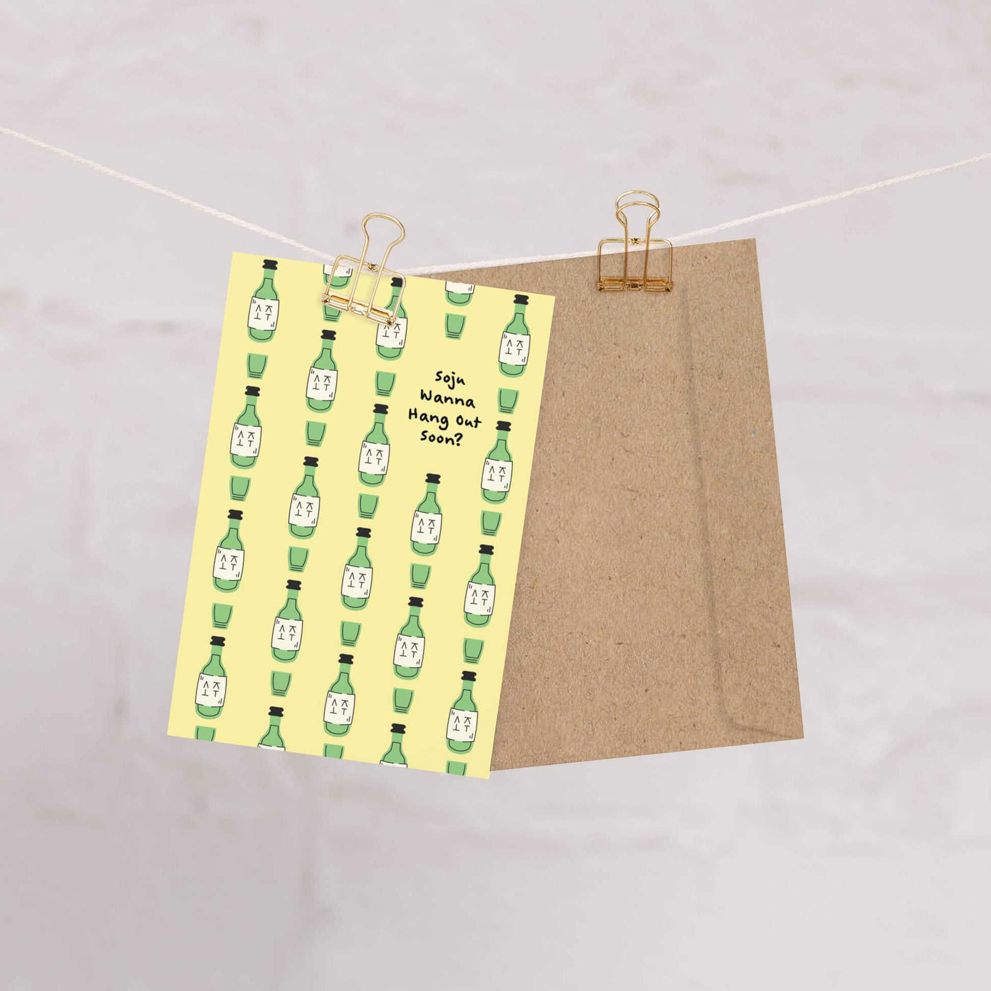 Card with green bottle pattern on yellow cover and brown back, clipped to a string.