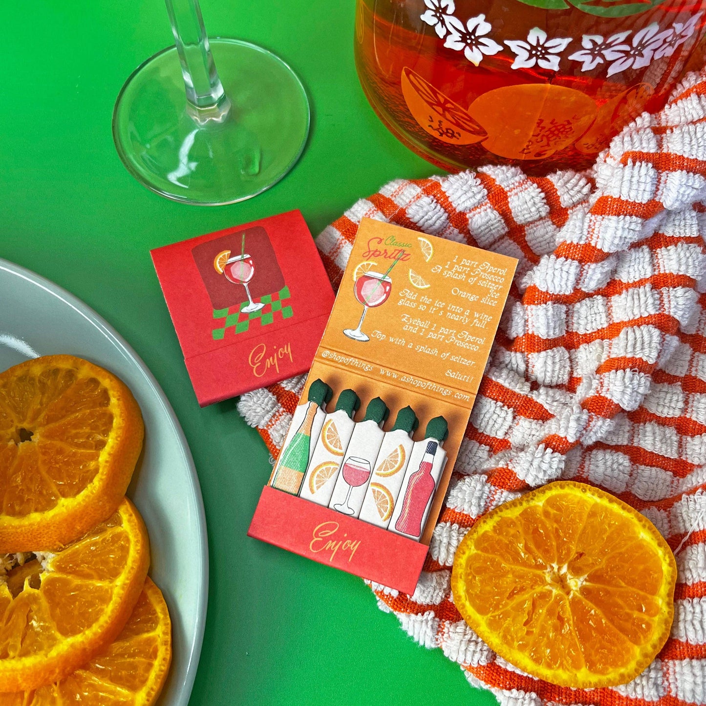 Negroni matchbook. Each match has a different ingredient on each match. Inside the matchbook is a recipe of how to make a spritz. The matchbook says Enjoy