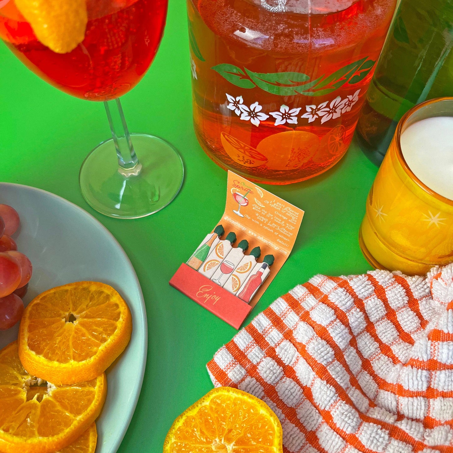 Negroni matchbook. Each match has a different ingredient on each match. Inside the matchbook is a recipe of how to make a spritz. The matchbook says Enjoy