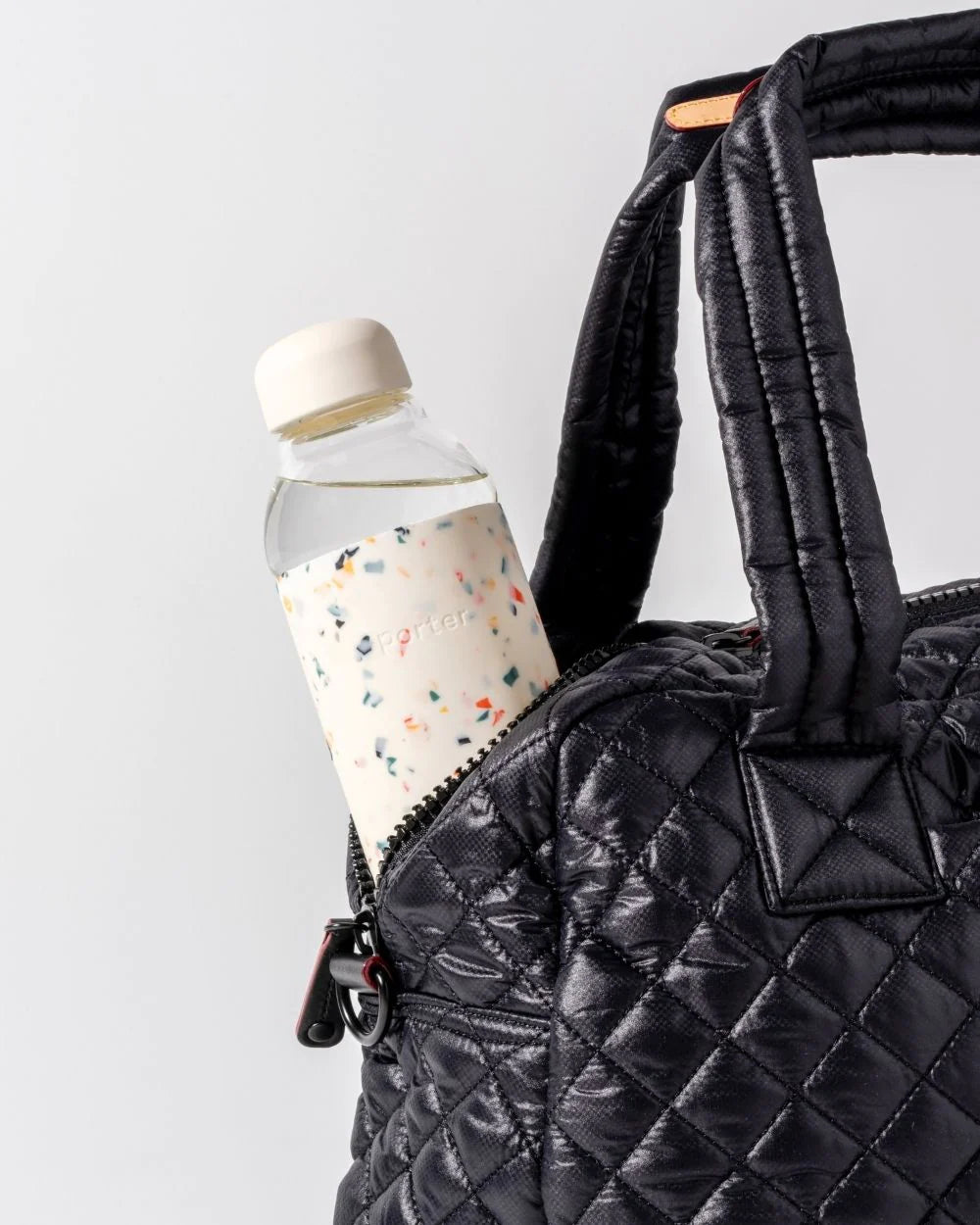 Glass reusable water bottle with terrazzo print silicone wrapped around for design and grip