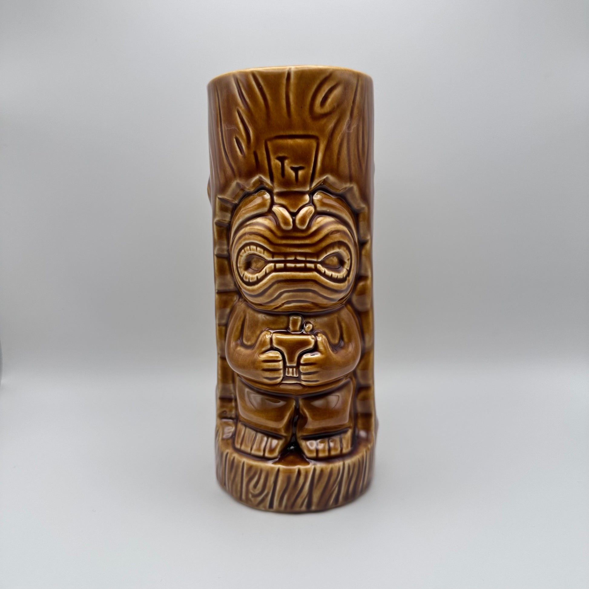 Brown tiki mug with tribal design on a white background