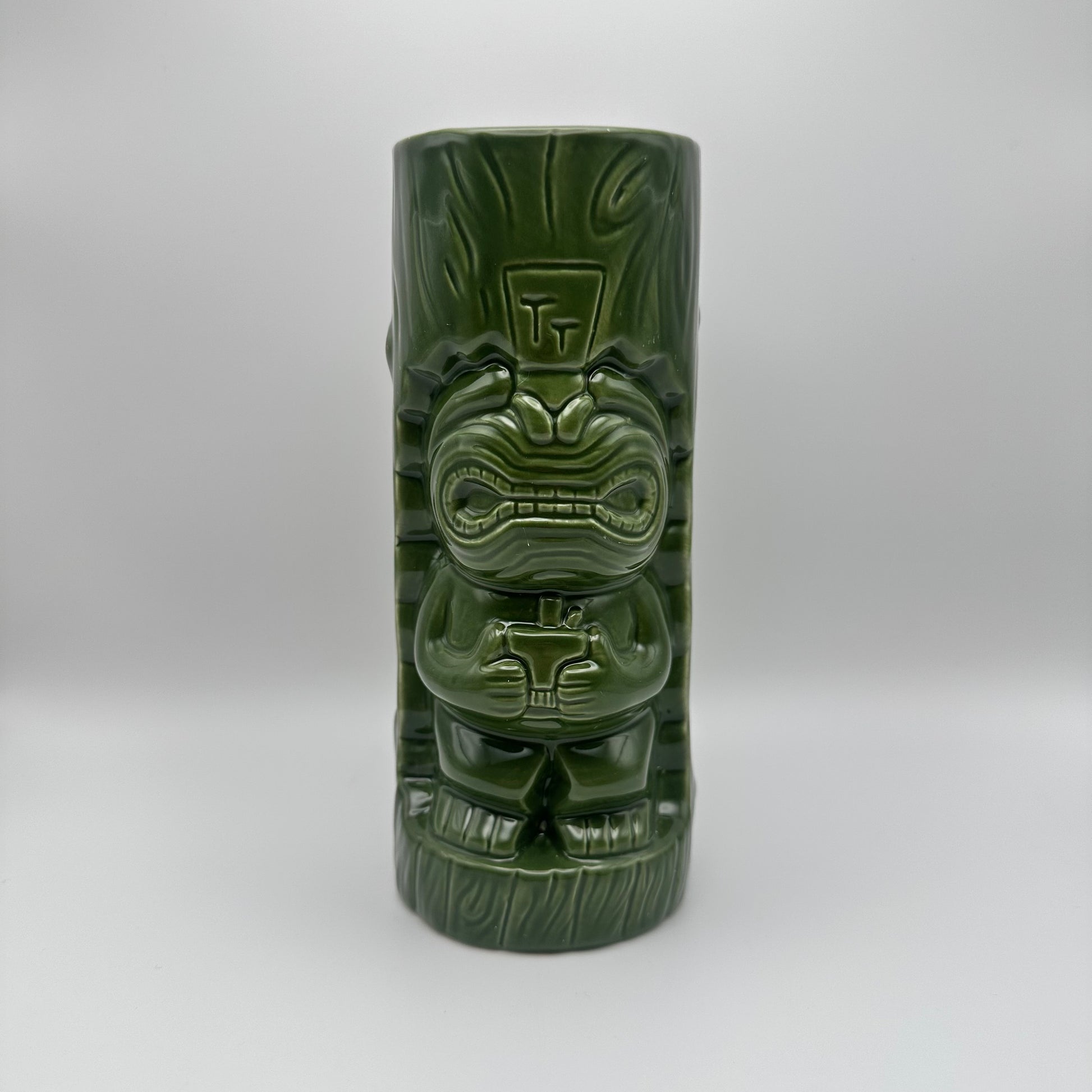 Green tiki mug with detailed design on a white background
