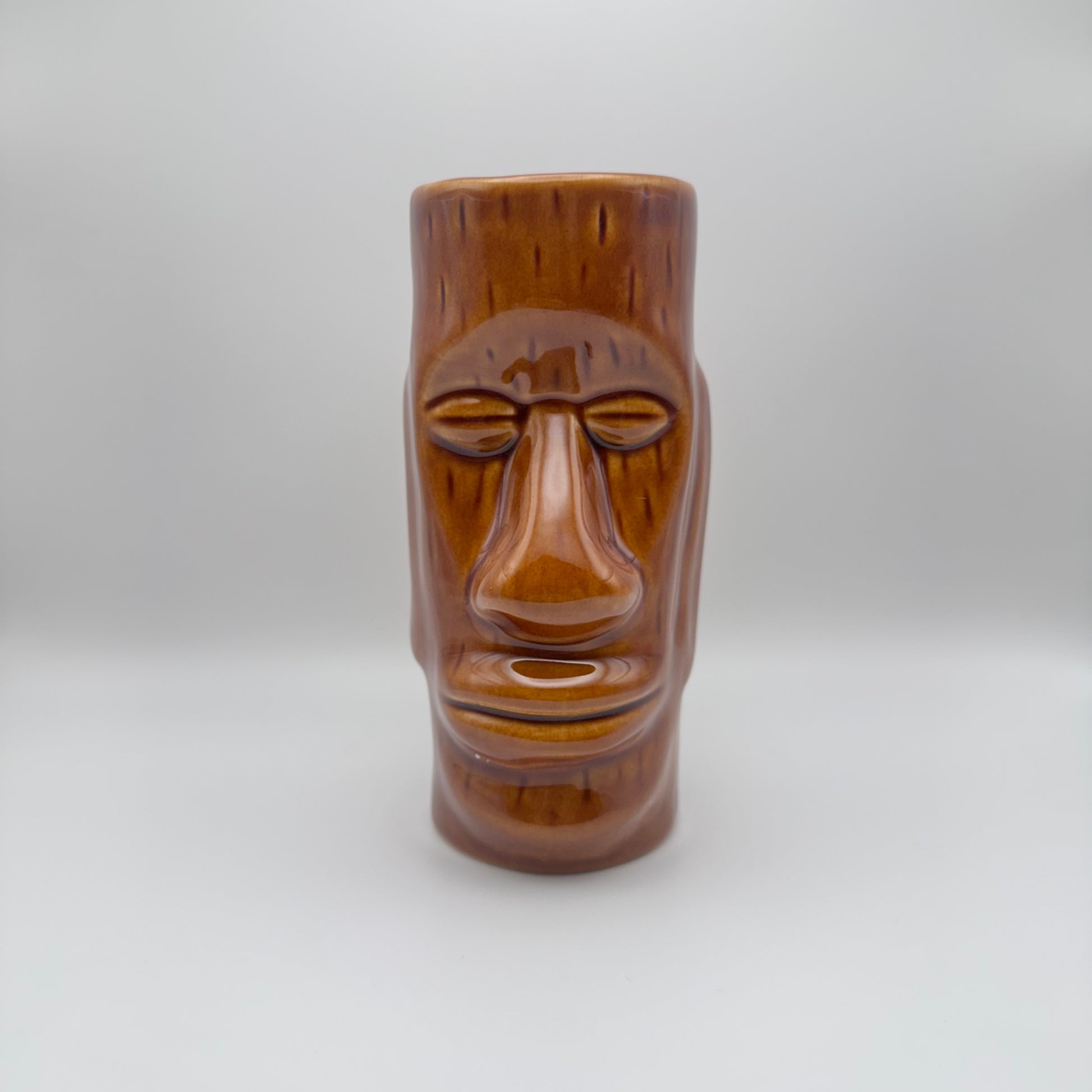 Wooden tiki mug with a face on a white background