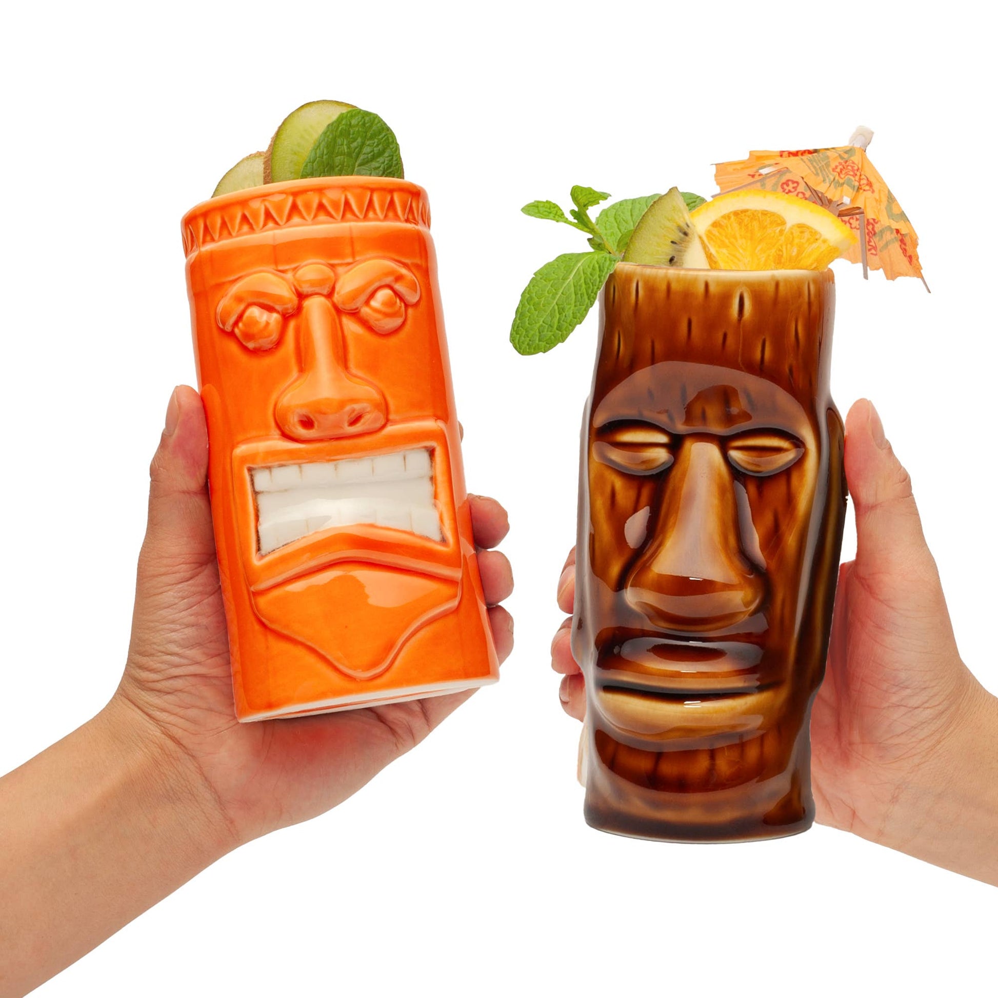 Two tiki-themed glasses held by hands, one orange and one brown, with drinks and garnishes.