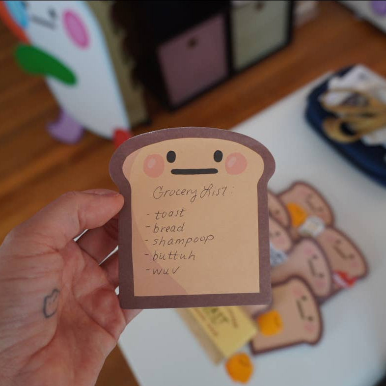 single sheet of toast it notes with grocery list written on it